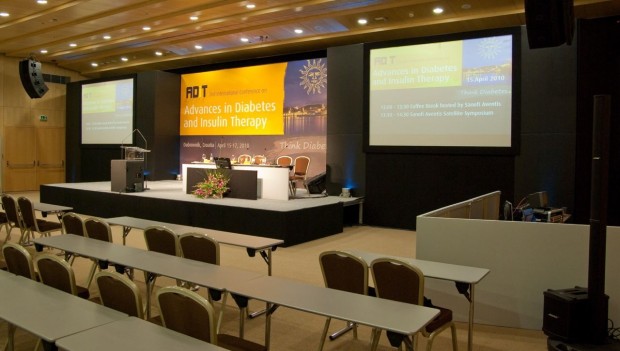 Professional conference room stage with projection screens and theater seating — a typical SpecGaff gaffer tape application environment