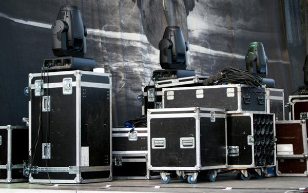 Professional AV road cases and moving head lighting fixtures staged for a live production event
