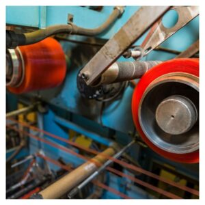 close up of industrial machinery, focused on rolls of tape on the machine